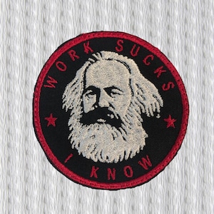May include: Embroidered patch with a black background and a red border. The patch features a portrait of Karl Marx with the text "WORK SUCKS I KNOW" in a circular design. The patch has a white background.