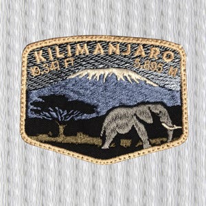 May include: Embroidered patch featuring a landscape scene with Mount Kilimanjaro, an elephant, and a tree. The patch includes the text "Kilimanjaro" and "19,341 ft" in gold lettering. The patch has a gold border and is set against a white background.