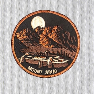 Op de afbeelding: Ronde geborduurde patch met een berglandschap onder een volle maan. Het ontwerp bevat bruine en oranje bergen, een witte maan en de tekst "MOUNT SINAI". De patch heeft een bruine rand.