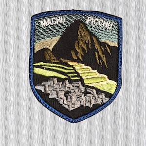 May include: Embroidered patch featuring a shield design with the words "MACHU PICCHU" above a mountain scene. The patch has a black background with a blue border and depicts a mountain, terraces, and ancient ruins.