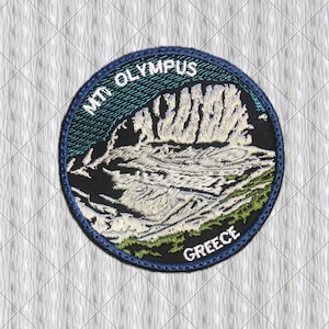 May include: A circular embroidered patch featuring a detailed depiction of Mount Olympus. The design includes white mountain peaks, green terrain, and a dark blue sky. The text "MT OLYMPUS" is arched at the top and "GREECE" is at the bottom.
