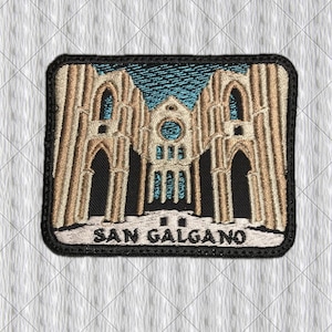 May include: A rectangular embroidered patch featuring a tan and beige depiction of the San Galgano Abbey ruins against a dark blue sky. The architectural design includes tall arched columns and a central rose window, with the text SAN GALGANO below.