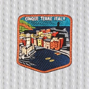 Op de afbeelding: Geborduurde patch met een kleurrijke afbeelding van Cinque Terre, Italië. De patch toont een kustplaats met gebouwen in tinten oranje, geel en wit, tegen een blauwe zee en lucht. De tekst "CINQUE TERRE ITALY" staat bovenaan.