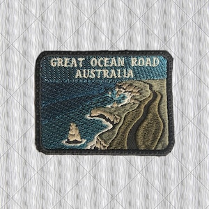 May include: Embroidered patch depicting a coastal scene with the text "GREAT OCEAN ROAD AUSTRALIA." The design shows a blue sea, cliffs, and a rock. The patch has a black border.