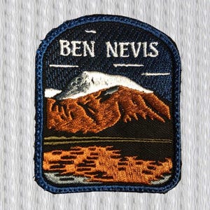 Può includere: Toppa ricamata con la scritta "BEN NEVIS" in alto. La toppa mostra una scena di montagna con dettagli marroni e bianchi, su uno sfondo di cielo blu scuro. La toppa ha un bordo blu navy e un paesaggio arancione e nero.