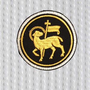 May include: Embroidered patch featuring a golden lamb holding a flag with a cross, set against a black background. The patch is circular, with a gold and white border, and is likely for religious or symbolic purposes.