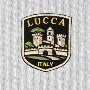 Könnte beinhalten: Gestickter Aufnäher mit dem Wort "LUCCA" über einer Burgillustration mit drei Türmen und einer Brücke. Das Wort "ITALY" steht darunter. Der Aufnäher hat einen schwarzen Hintergrund mit goldenen, grünen und beigen Details.