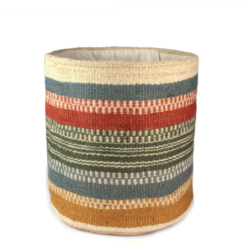 May include: A cylindrical woven storage basket with a natural jute base and colorful striped pattern in shades of blue, green, red, and yellow.