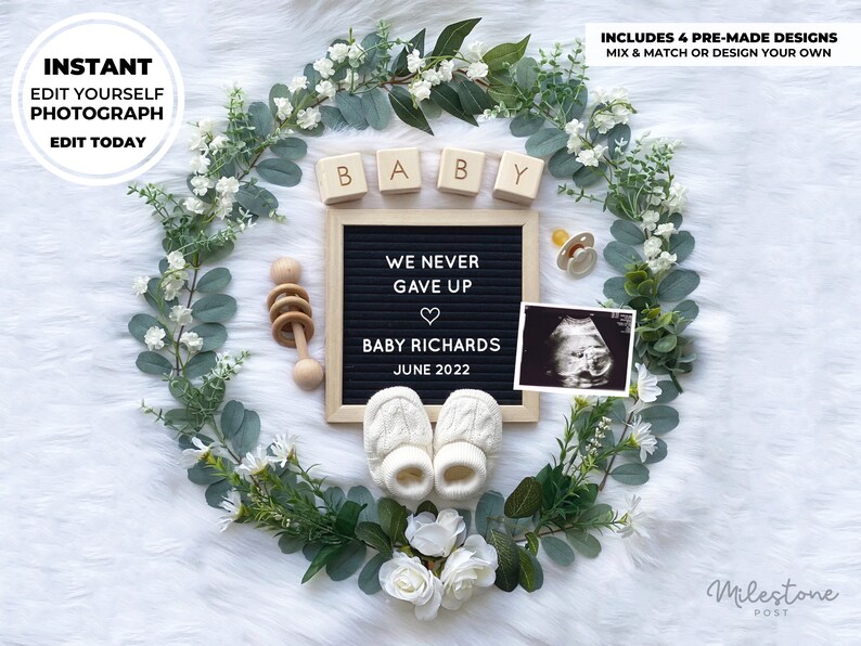 May include: A black letter board with the text "We never gave up" and a heart symbol. Below the text is "Baby Richards" and "June 2022". The letter board is surrounded by a wreath of eucalyptus leaves and white flowers. There are wooden blocks that spell "BABY" and a pacifier, a rattle, and a sonogram image.