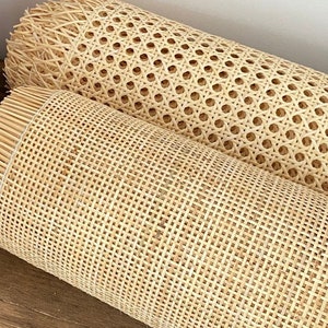 Puede incluir: Dos rollos de tejido de ca&ntilde;a natural, uno con tejido cuadrado y el otro con tejido redondo. Los rollos est&aacute;n sobre una superficie de madera.
