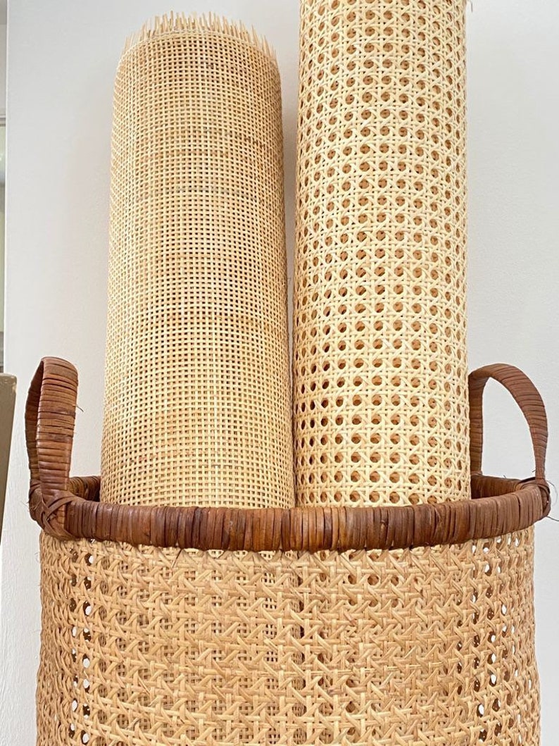 Puede incluir: Dos rollos de tejido de ca&ntilde;a natural en una cesta de mimbre tejida con asas marrones. El tejido se utiliza para los asientos y respaldos de las sillas.