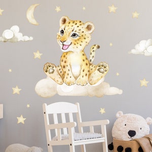 Op de afbeelding: Een aquarel-illustratie van een schattig luipaardjong dat op een wolk zit met sterren en een halve maan op de achtergrond. De illustratie is gedrukt op een witte achtergrond.