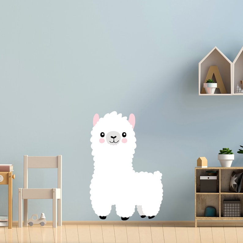 May include: A white fluffy llama with pink ears and a black nose, standing on a light wood floor in front of a light blue wall.