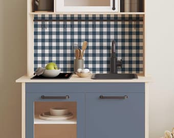 Può includere: Un rivestimento da cucina a quadri blu e bianchi con un rubinetto nero e un piano cottura nero. La cucina è in legno e ha un armadio blu con una porta in vetro.