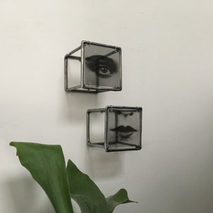 Two piece of 3d wall art, eye and lips, in Pop art style. Sculpture by Artandshadow with plant in background