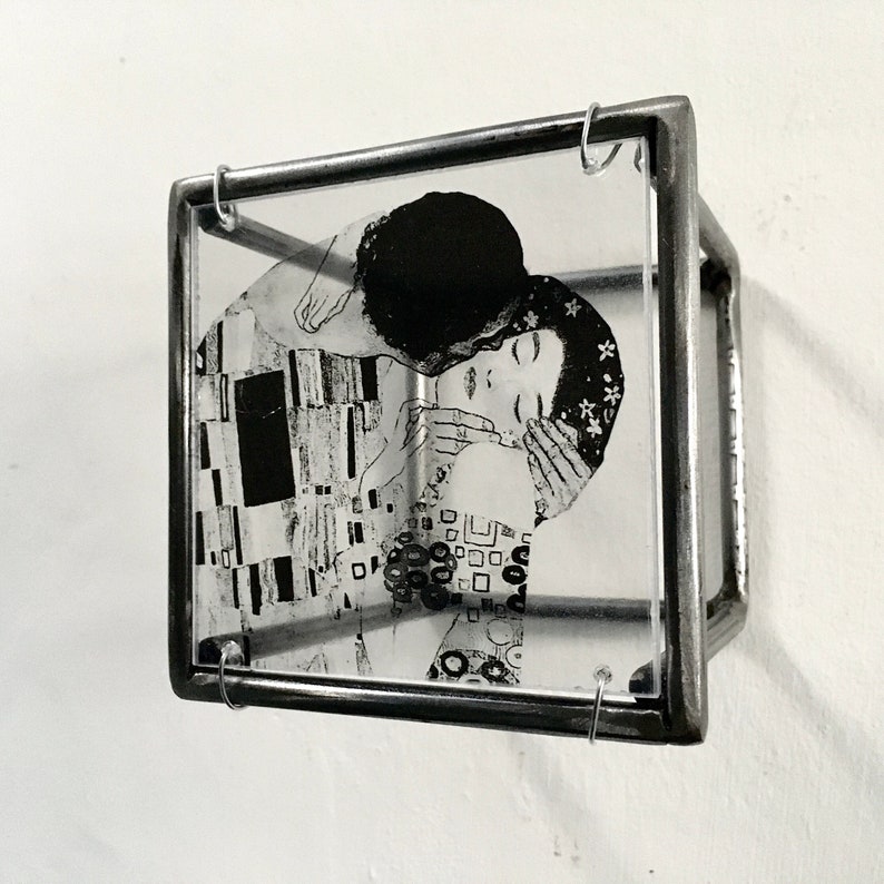May include: A black and white image of a couple embracing, framed in a silver metal frame with glass.