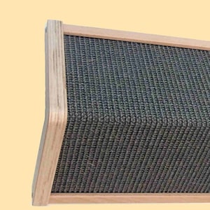 May include: A rectangular wooden speaker with a grey fabric grille. The speaker is angled slightly upwards.