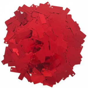 May include: A large pile of red rectangular sequins. The sequins are shiny and have a metallic finish.