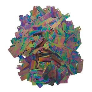 Könnte beinhalten: Ein großer Haufen regenbogenfarbener rechteckiger Pailletten mit holografischem Finish. Die Pailletten sind in einem Mix aus Lila, Grün, Blau und Gold.