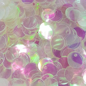 May include: A pile of iridescent white round sequins with a hole in the center.