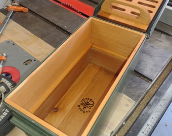 May include: A green metal ammo can with a wooden insert and a divider. The wooden insert has a bee logo with the text "Lee Bee Designs".
