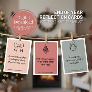 Puede incluir: Descarga digital de tarjetas de reflexión de fin de año. Se muestran tres tarjetas, cada una con una indicación diferente y una ilustración sencilla. Las tarjetas son en tonos rosa y verde, y están sujetas con pinzas de madera en una cuerda.