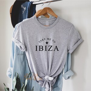 May include: Gray t-shirt with the text "Take Me To Ibiza" and a black star.
