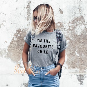Peut inclure: Un t-shirt gris avec le texte "I'm the favourite child" imprim&eacute; en noir.