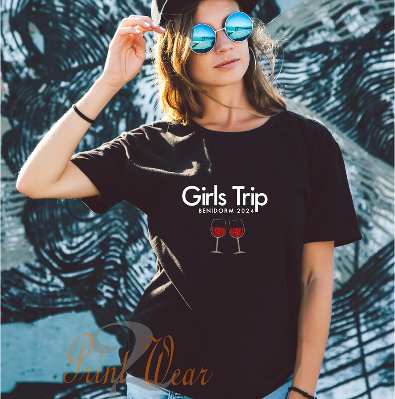 Pode incluir: Camiseta preta com texto branco que diz "Girls Trip Benidorm 2024" e duas ta&ccedil;as de vinho tinto.