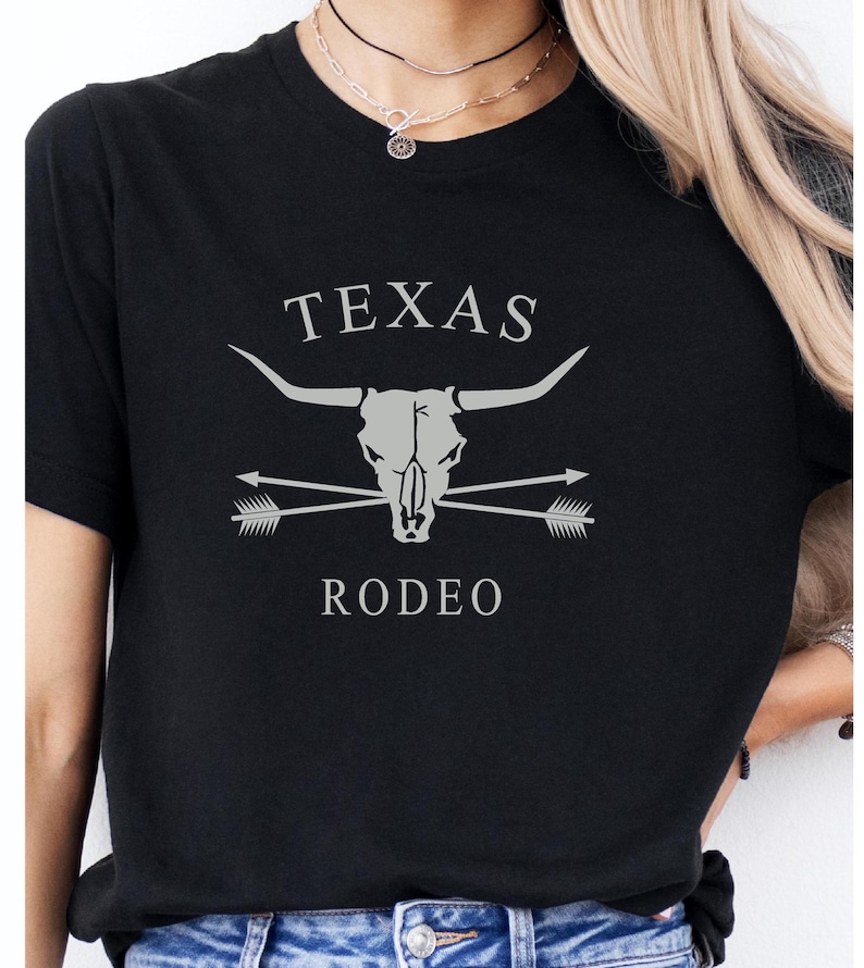 May include: Black t-shirt with a white graphic of a steer skull with crossed arrows and the text "TEXAS RODEO".
