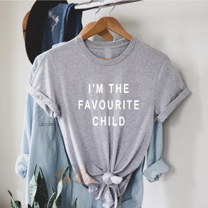 Peut inclure: Un t-shirt gris avec le texte "I'm the favourite child" imprim&eacute; en blanc sur le devant.