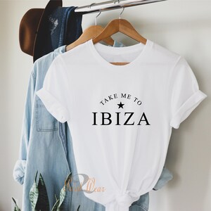 May include: White t-shirt with black text that reads "Take Me To Ibiza" with a black star above the word "Ibiza".