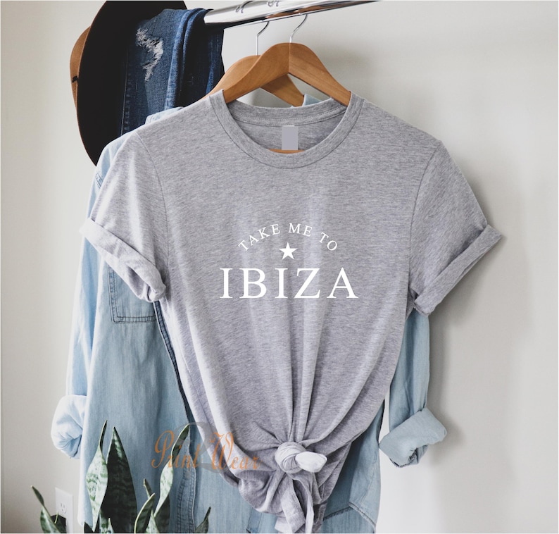 May include: Gray t-shirt with white text that reads "Take Me To Ibiza" with a white star above the word Ibiza.