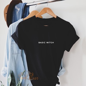 May include: Black t-shirt with the text "BASIC WITCH" in white lettering.