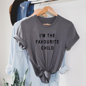 Peut inclure: Un t-shirt gris avec le texte "I'm the favourite child" imprim&eacute; en noir.