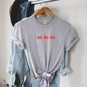May include: A gray t-shirt with the text "Blah, Blah, Blah" in red lettering.