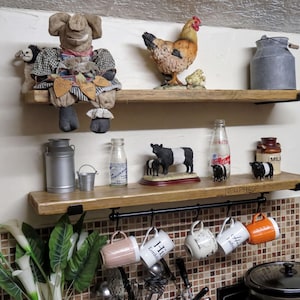 a kitchen shelf with various items, including a stuffed animal, a chicken, a cow, and several mugs hanging from a rack.