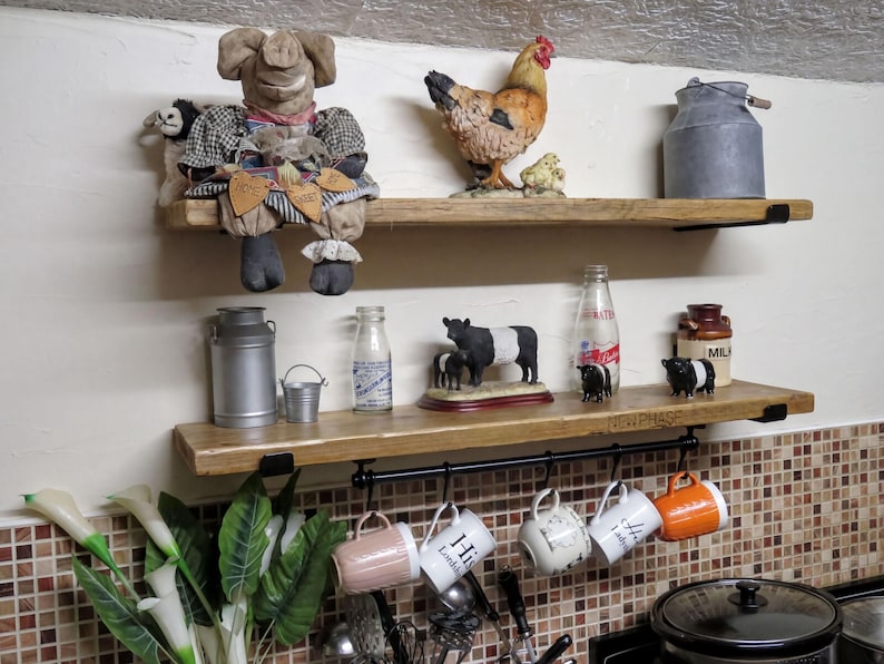 a kitchen shelf with various items, including a stuffed animal, a chicken, a cow, and several mugs hanging from a rack.