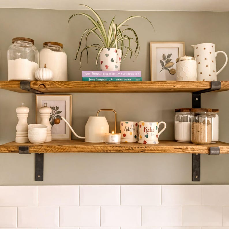 A cozy kitchen scene with a wooden shelf displaying various kitchen items, including jars, a potted plant, and decorative objects.