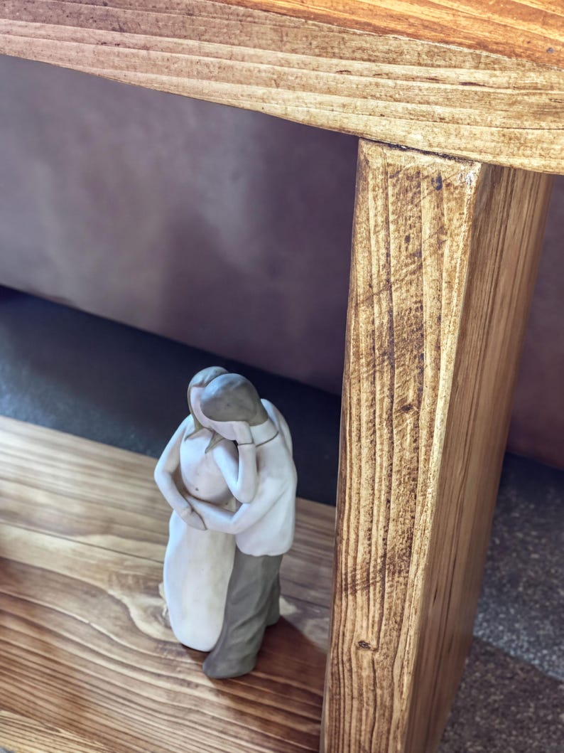 A small ceramic figurine of a couple embracing is placed on a wooden surface.