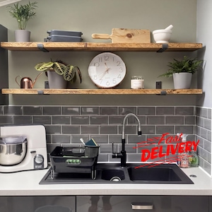 a kitchen counter with various kitchen items, including a sink, a clock, a blender, and a potted plant. There is also a "Fast Delivery" sign on the counter, indicating that the kitchenware is being delivered quickly.