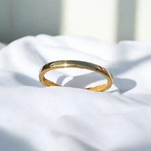May include: A simple gold bangle bracelet with a smooth, polished finish.
