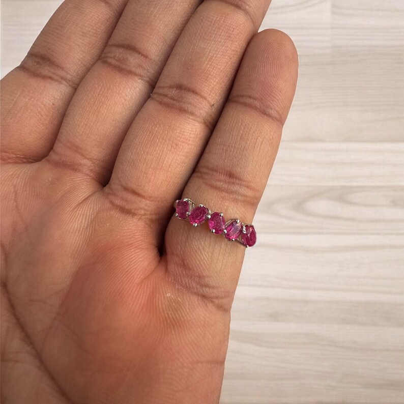 Peut inclure: Une bague en argent avec une rang&eacute;e de pierres ovales roses.