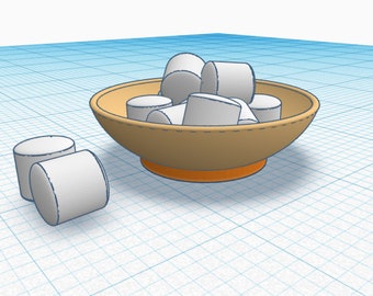 May include: A brown bowl with a stitched rim and orange base filled with white marshmallows. Two additional marshmallows are on the table next to the bowl.