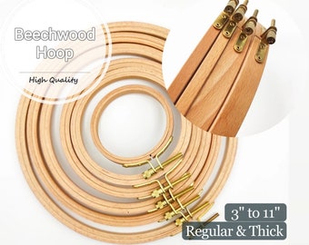 May include: A set of 9 wooden embroidery hoops in various sizes, ranging from 3 inches to 11 inches. The hoops are made of natural beechwood and have a smooth finish. The hoops are stacked on top of each other, with the largest hoop at the bottom and the smallest hoop at the top. The hoops are held together by a brass screw mechanism.