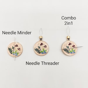 May include: A mushroom-themed needle minder and needle threader combo. The needle minder is a round, cream-colored metal disc with a mushroom design. The needle threader is a small, metal loop with a needle attached to it. The text "Combo 2in1" is written above the needle threader.