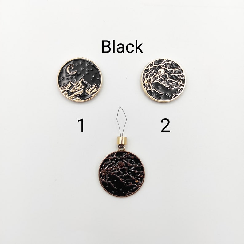 May include: Three circular black and gold metal charms labelled Black. Item 1 features a crescent moon and stars. Item 2 and the bottom charm display a detailed tree branch design. The bottom charm includes a small gold loop with a thin wire threader.
