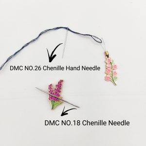 May include: Two chenille needles with floral embellishments. The needle on the left is a DMC No. 18 chenille needle, and the needle on the right is a DMC No. 26 chenille hand needle.