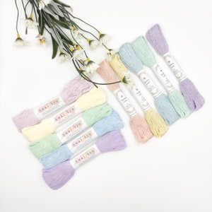 May include: Six skeins of pastel colored embroidery floss, each with a white label that reads "Awai-iro" and "Sashiko Lami".