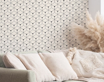 May include: A light green sofa with beige pillows and a cream-colored throw blanket. A wooden side table with a grid design holds a vase and a decorative glass piece. A geometric patterned wall art and pampas grass complete the cozy living room setting.